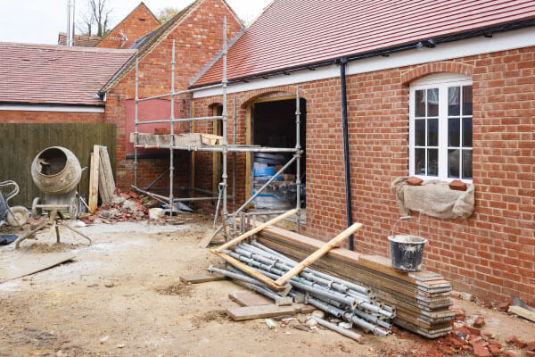 House under construction with building materials and scaffolding